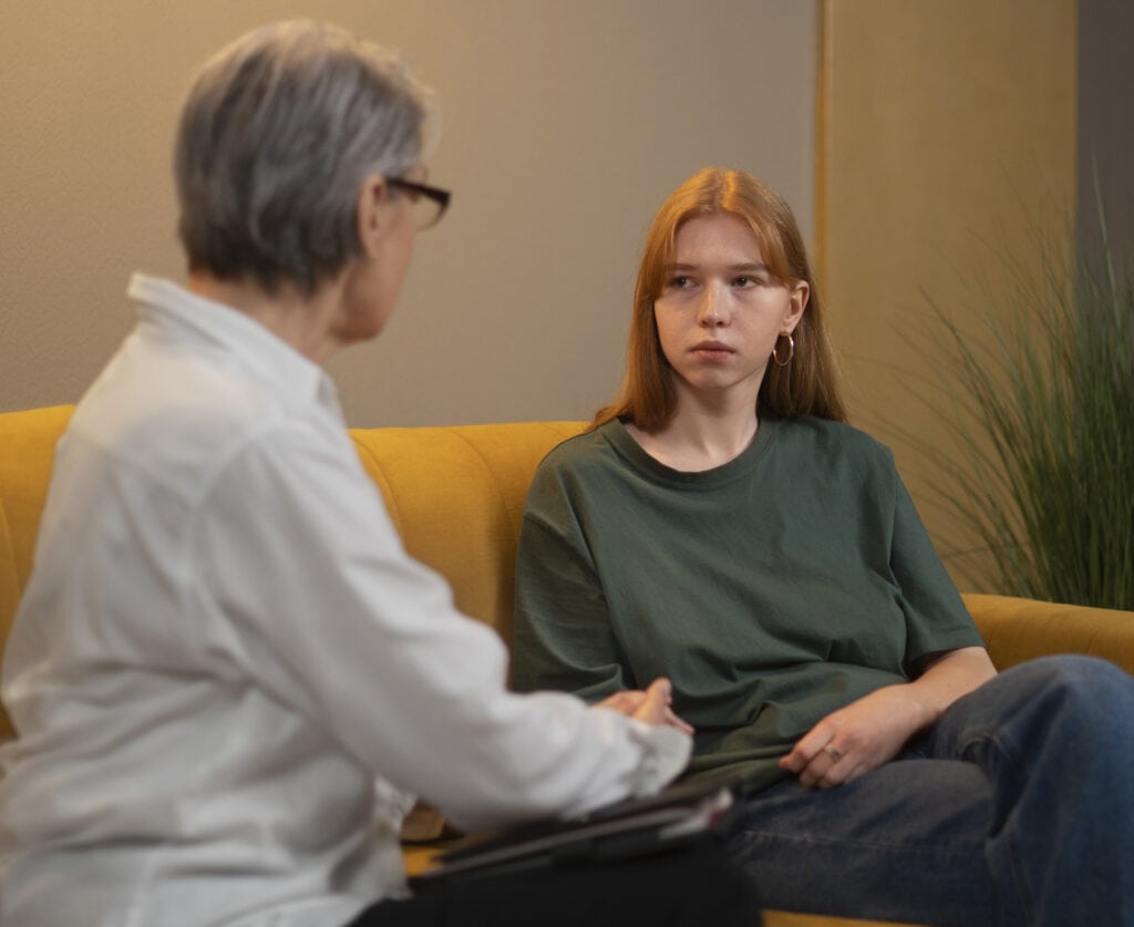 A teenaged girl speaks to a female counselor