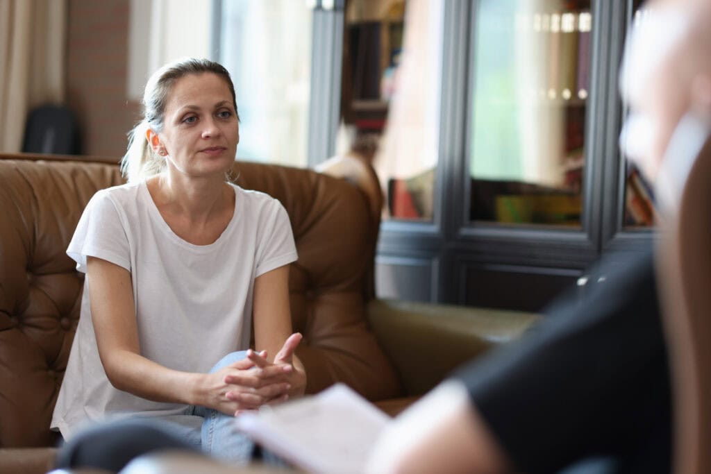 Woman with emotional issues visits psychologist office female patient listens man doctor